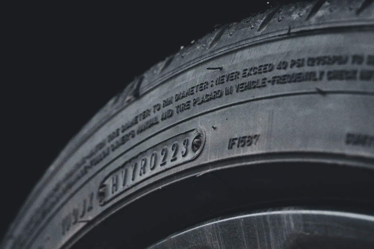 Detailed close-up image of a black car tire showcasing sidewall text and treads.