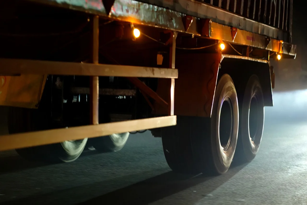 Dynamic close-up of truck wheels moving on an Indian road at night.
